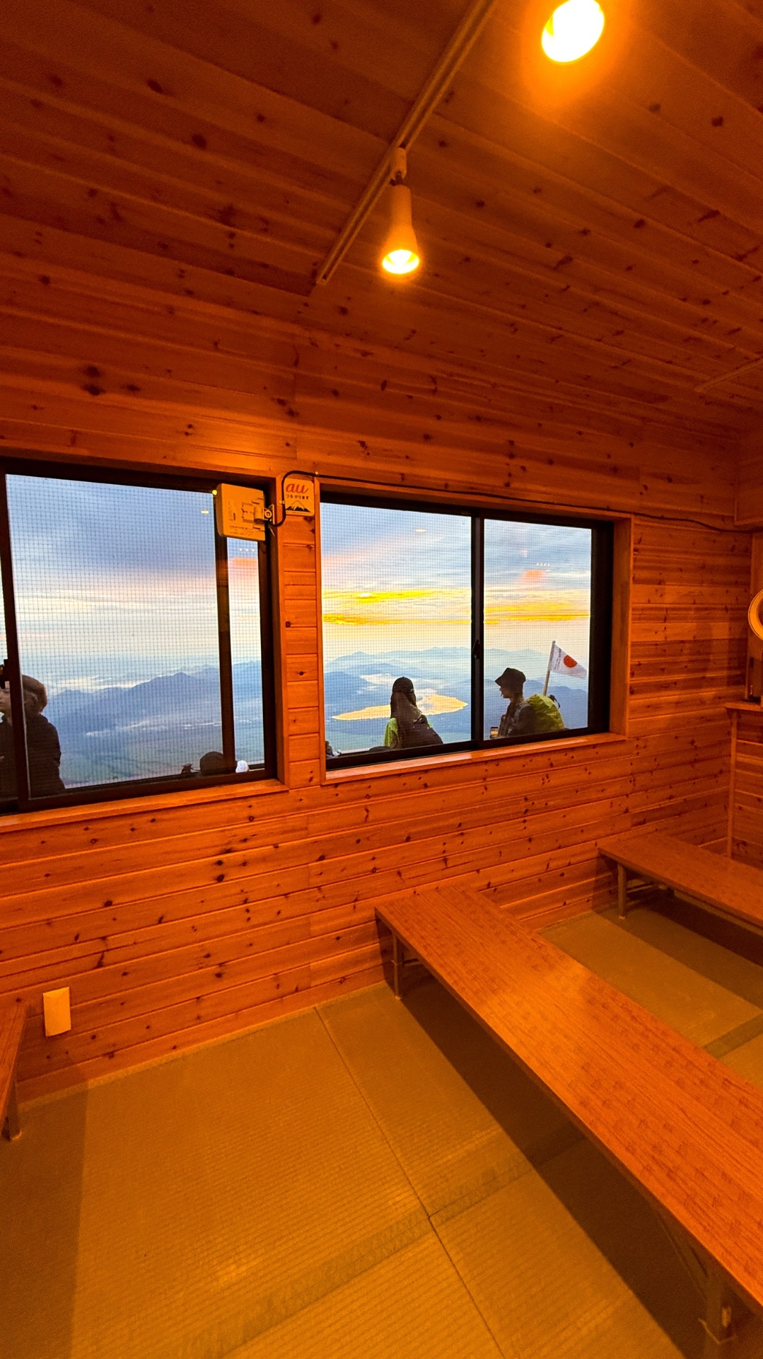 Inside a Mount Fuji mountain hut at sunset, looking out over the lakes